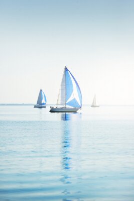 Sailing yacht regatta. Modern sailboats racing with blue spinnaker sails. Clear summer day. Kiel, Germany. Sport and recreation, transportation, private wessel, vacations