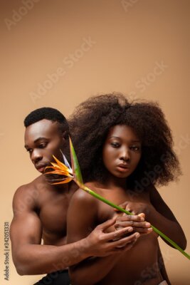 Papier peint  sexy naked african american couple posing with Strelitzia flower on beige