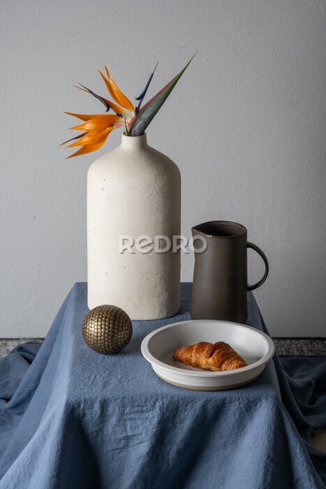 Papier peint  Still life on a gray background: croissant, strelitzia flower
