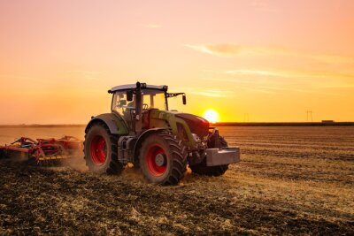 Papier peint  Tracteur dans un champ au coucher du soleil