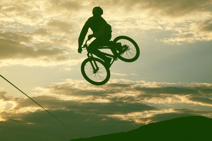 Papier peint  Un homme fait des cabrioles sur un BMX