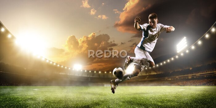 Papier peint  Un joueur de football en action dans un stade illuminé