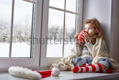 Papier peint  Une enfant avec une tasse près d'une fenêtre