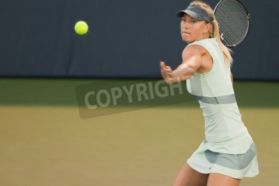 Papier peint  Une joueuse de tennis joue une balle