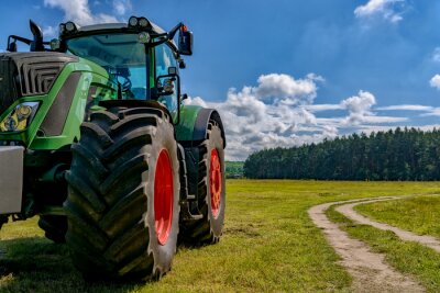 Papier peint  Une partie du tracteur debout dans un champ près de la route.