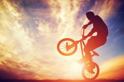 Vélo BMX et un homme au coucher de soleil