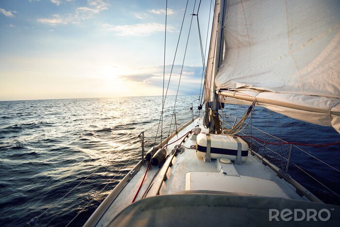 Papier peint  View from the deck to the bow of a sail yacht tilted in a wind on a sunset