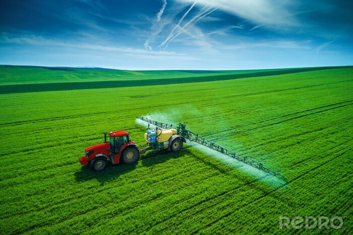Papier peint  Vue aérienne du tracteur agricole labourant et pulvérisant sur le terrain