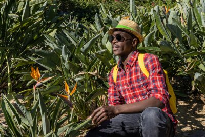 Papier peint  Young African visiting a botanical garden with a plant called Strelitzia.