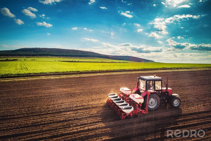 Poster  Agriculteur avec tracteur ensemencement des cultures au champ, vue aérienne de drone