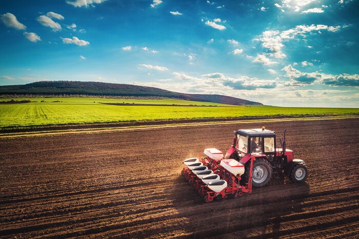 Poster  Agriculteur avec tracteur ensemencement des cultures au champ, vue aérienne de drone