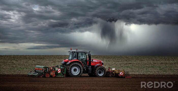 Poster  beautiful landscape with a farmer plowing his fields before the storm
