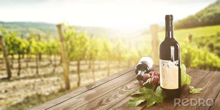 Poster  Bouteilles de vin avec une vigne en arrière-plan