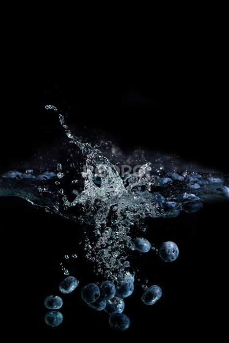 Poster  bright juicy fruits with splashes fly into the aquarium on a black background