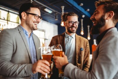 Poster  Business people drink beer after work in pub. Businessmen enjoy a beer.