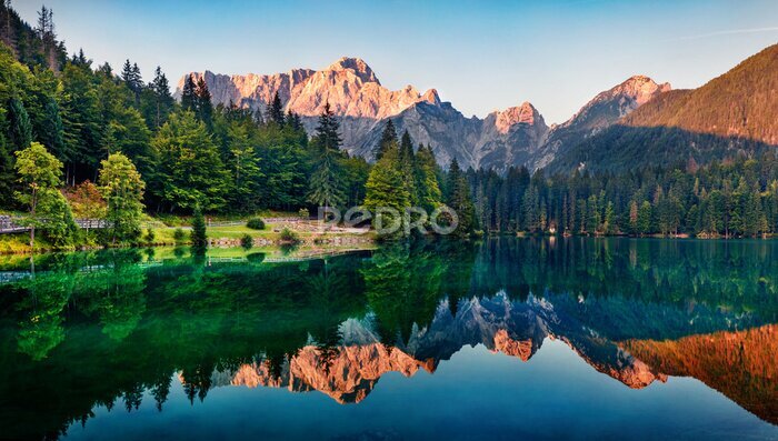 Poster  Calm morning view of Fusine lake. Colorful summer sunrise in Julian Alps with Mangart peak on background, Province of Udine, Italy, Europe. Beauty of nature concept background.