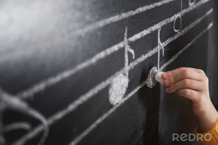 Poster  Child writing music notes on blackboard, closeup