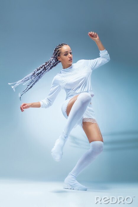 Poster  Danseuse de fille fitness excité attrayant en danse de sportwear isolé sur fond bleu. Concept de mode et de style de vie.