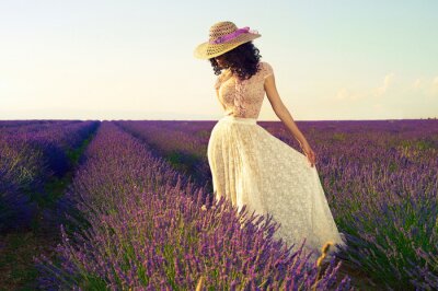 Femme avec un chapeau dans un champ de lavande