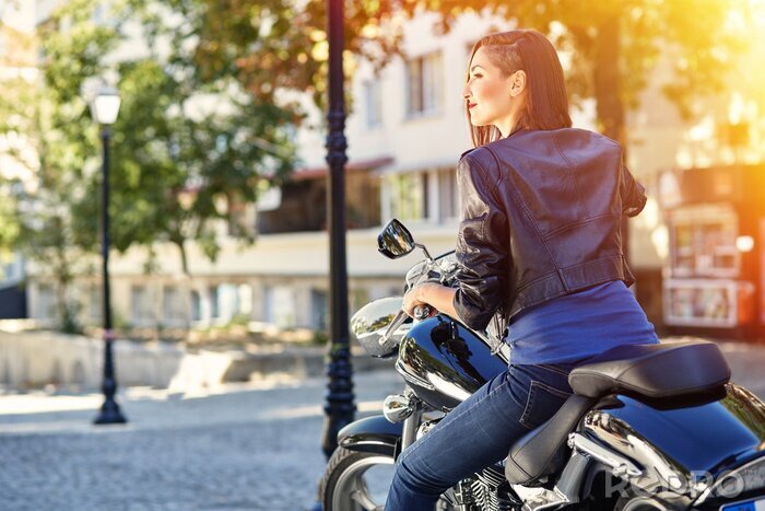 Poster  fille de motard dans une veste en cuir sur une moto