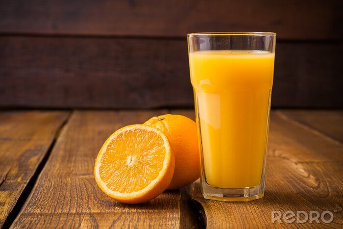 Poster  Fruits Orange et verre de jus sur fond de bois brun