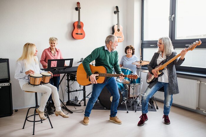 Poster  Group of senior people playing musical instruments indoors in band.