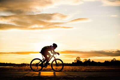 Homme silhouette cyclisme au coucher du soleil