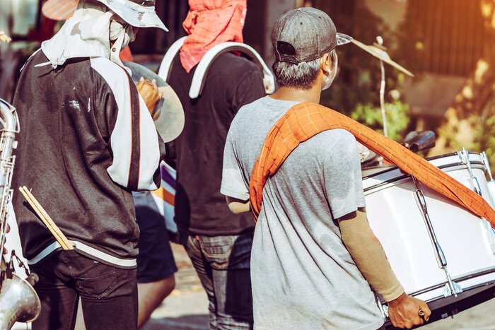 Poster  Jazz music parade of Thai happiness people wearing colorful clothes in famous Songkran Water Festival on street in Kanchanaburi, Thailand.