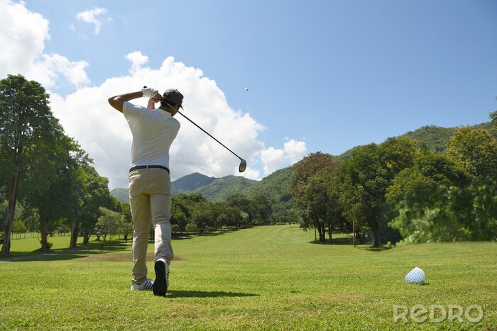Poster  Jeune homme asiatique jouant au golf sur un magnifique parcours de golf naturel