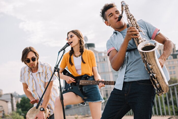Poster  Jeunes multiraciales avec guitare, djembé et saxophone se produisant dans la rue