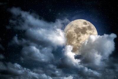 Lune apparaissant derrière des nuages duveteux