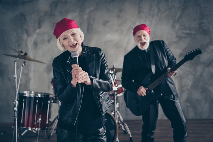 Poster  Photo of wife husband retired lady man rock famous group perform concert play guitar sing karaoke mic night club wear trendy rocker leather outfit isolated grey concrete wall background