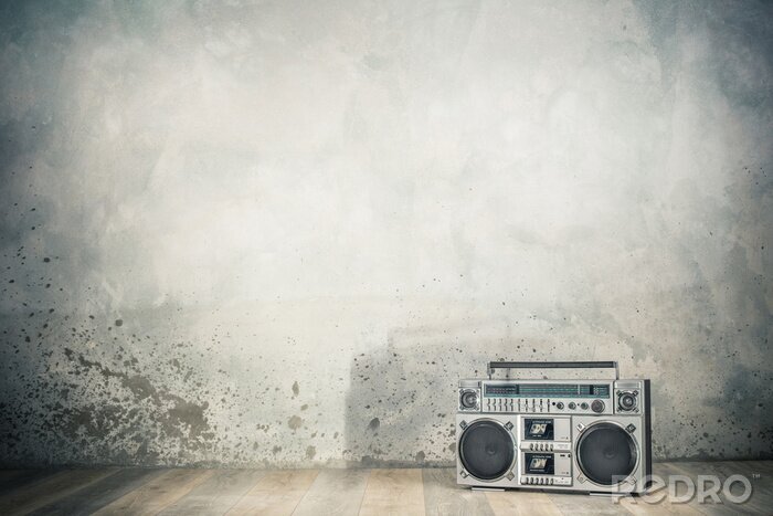 Poster  Retro outdated portable stereo boombox radio cassette recorder from 80s front concrete wall background with shadow. Vintage old style filtered photo