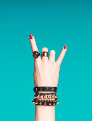 Rock hand sign, female hand punk rock gesture with gold wrist bracelets and finger rings isolated, creative art protest banner, fashion hipster accessories, 3d rendering
