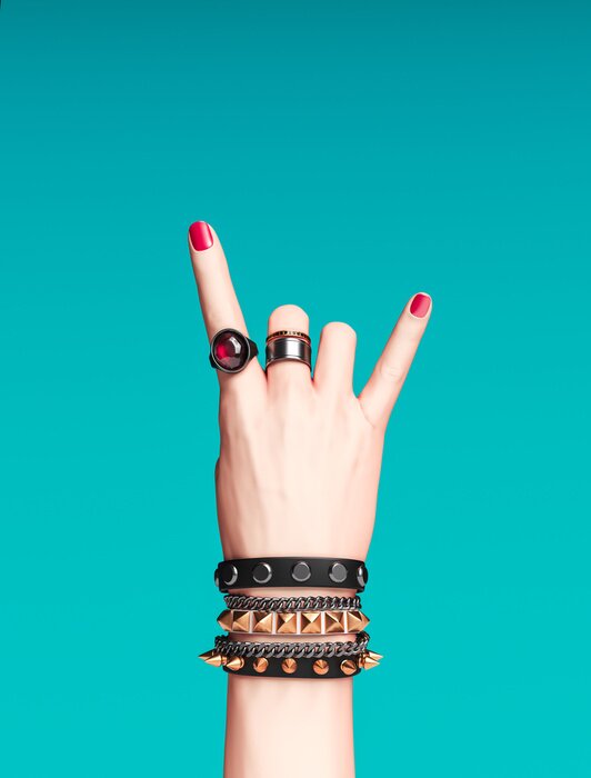 Poster  Rock hand sign, female hand punk rock gesture with gold wrist bracelets and finger rings isolated, creative art protest banner, fashion hipster accessories, 3d rendering