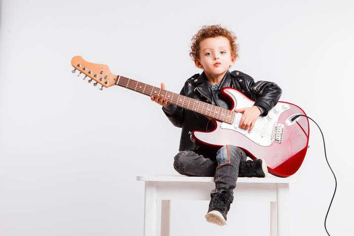 Poster  Shot of a little curls boy playing rock music with electric guitar.