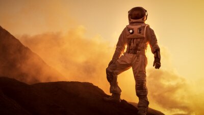 Silhouette de l'astronaute debout sur la montagne rocheuse de la planète rouge extraterrestre / Mars. Première mission habitée sur Mars. Exploration spatiale, colonisation.