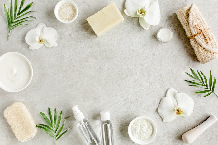 Poster  Spa skincare concept. Natural/Organic spa cosmetics products, sea salt and tropic palm leaves on gray marble table from above. Spa background with a space for a text, flat lay, top view.