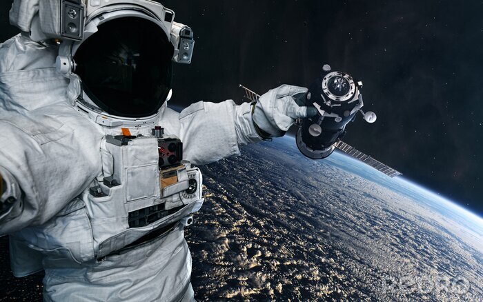 Poster  The astronaut holds in his hand a space station in orbit of the Earth. Solar system. Science fiction. Elements of this image furnished by NASA
