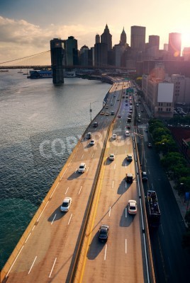 Trafic intense à New York Manhattan avec Brooklyn Bridge across Hudson River au coucher du soleil.