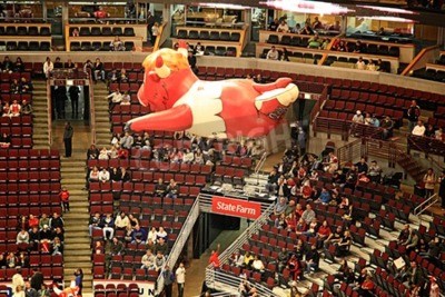 Poster  Un ballonnet gonflable de Benny Bull, communément connu sous le nom de Benny, la mascotte officielle des Chicago Bulls de la National Basketball Association, planant au-dessus de la NBA United Center,