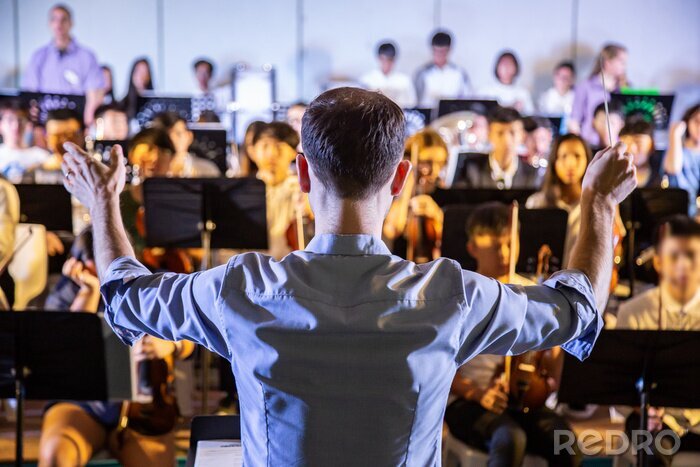 Poster  Un chef d’école conduisant son groupe d’élèves à jouer de la musique lors d’un concert scolaire