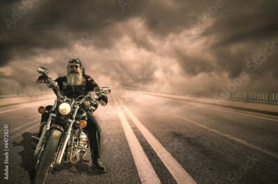Poster  Un motard à la longue barbe se détachant sur un ciel nuageux