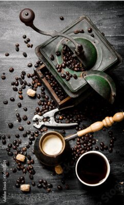Poster  Une tasse de café à côté d'un vieux moulin à café rétro