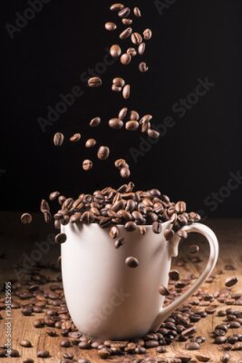 Poster  Une tasse en céramique remplie de grains de café