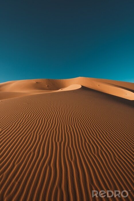 Poster  Vertical shot of a peaceful desert under the clear blue sky captured in Morocco