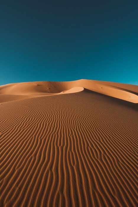 Poster  Vertical shot of a peaceful desert under the clear blue sky captured in Morocco