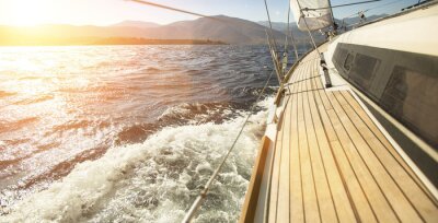 Voilier aux coucher du soleil fond montagnes