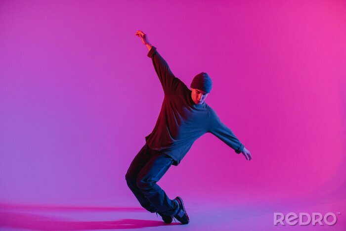 Poster  Young Man in a Jumper Dancing Contemporary Dance in Studio. Breakdancing. Dance School Poster. Copy Space. Battle competition announcement. Pink and Blue Background.