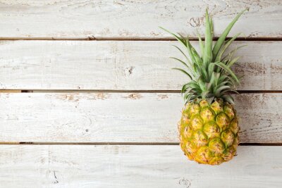 Sticker  Ananas allongé sur une table en bois